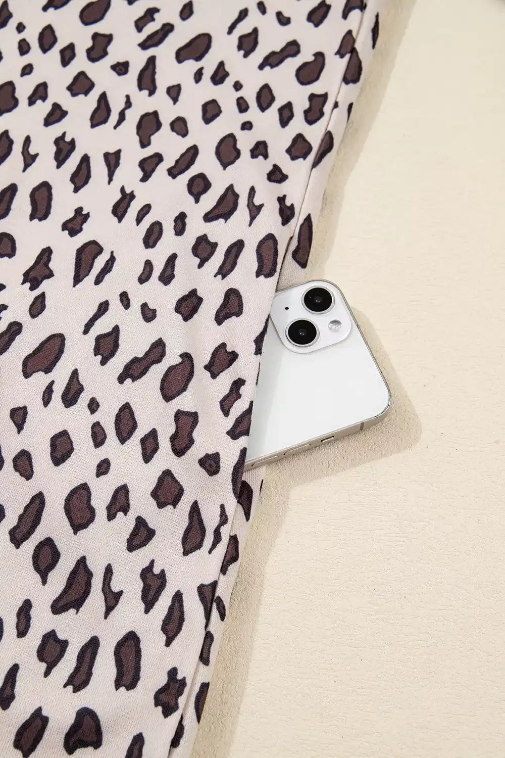 Leopard print fabric with a smartphone in the side pocket, stylish fashion detail