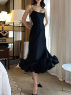 Black satin midi dress with ruffled hem, spaghetti straps, and elegant fit for women's boutique fashion