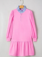 Pink long sleeve dress with ruffled hem and blue striped collar, hanging on a hanger