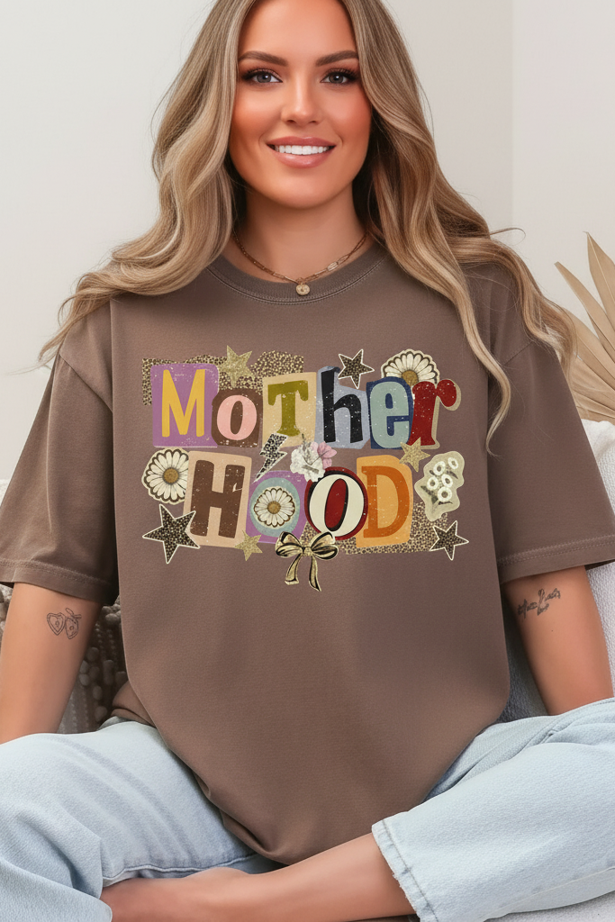 Woman wearing a brown t-shirt with 'Mother Hood' printed on it, sitting on a couch.