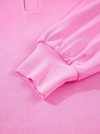 Close-up of pink long-sleeve sweatshirt with ribbed cuff, soft knit fabric