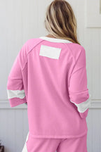 Woman wearing pink lounge set with white color block accents, viewed from the back