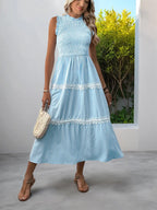 Light blue striped tiered midi dress with lace trim, sleeveless smocked bodice, paired with woven bag and sandals