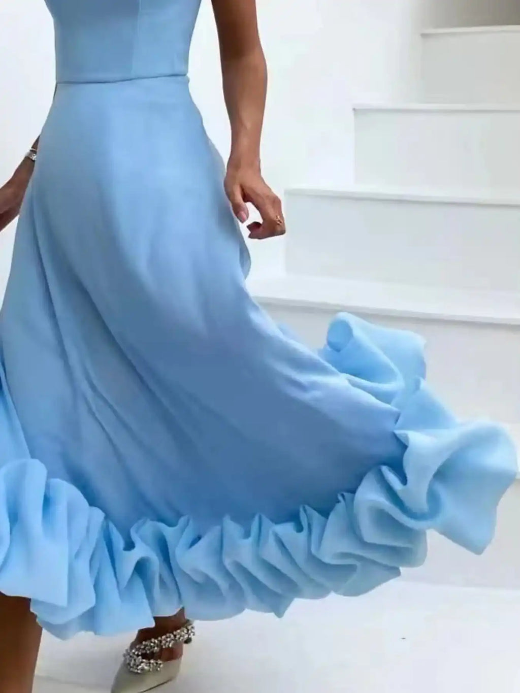 Elegant light blue ruffled maxi dress with flowing skirt and embellished heels