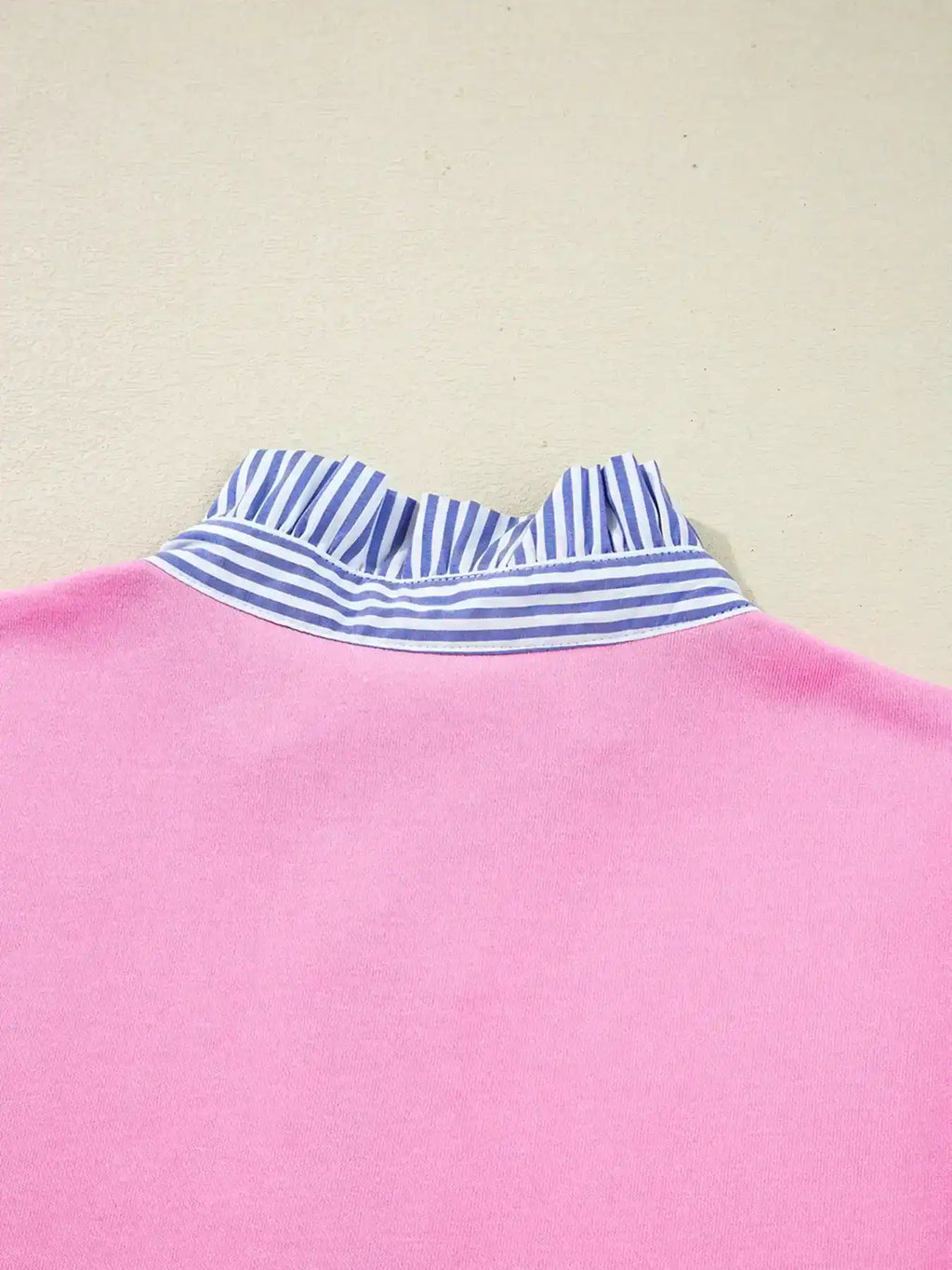 Pink top with blue and white striped ruffled collar, close-up of back neckline.