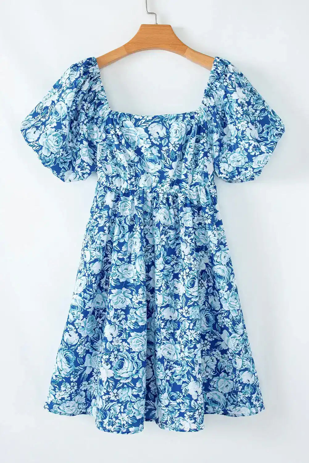 Blue floral puff sleeve summer dress with square neckline hanging on wooden hanger