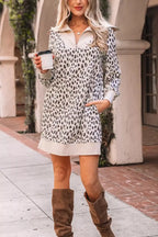 Woman wearing a casual leopard print sweater dress with boots, holding coffee outdoors