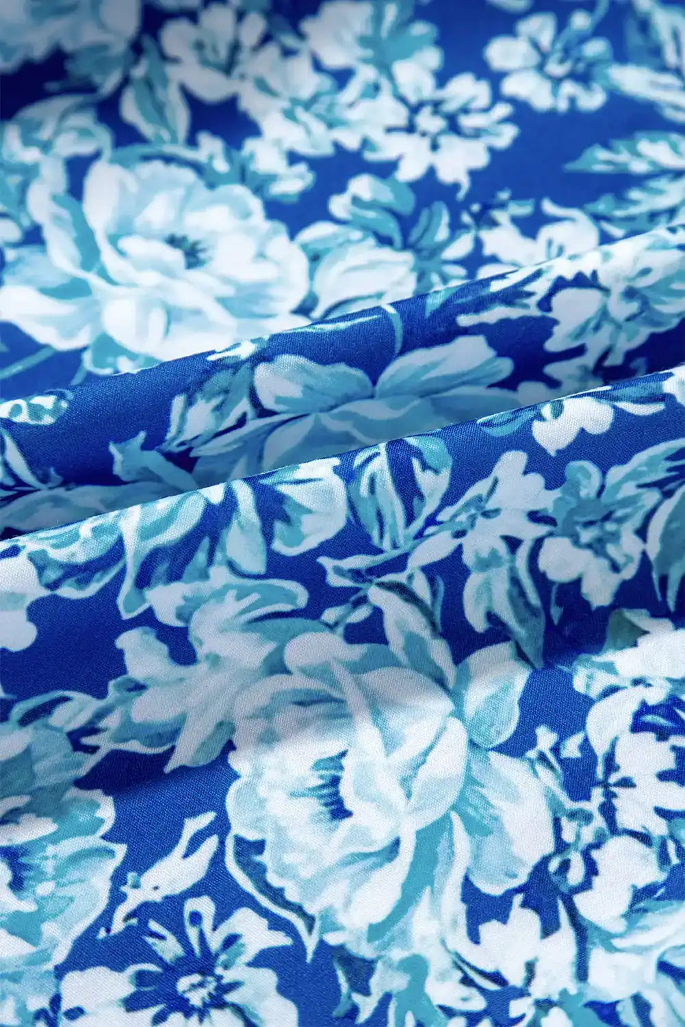 Blue floral fabric with white and light blue botanical pattern, closeup texture