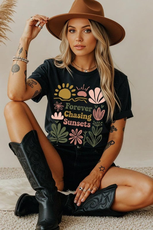 Woman wearing a black t-shirt with floral designs and text, sitting on the floor.