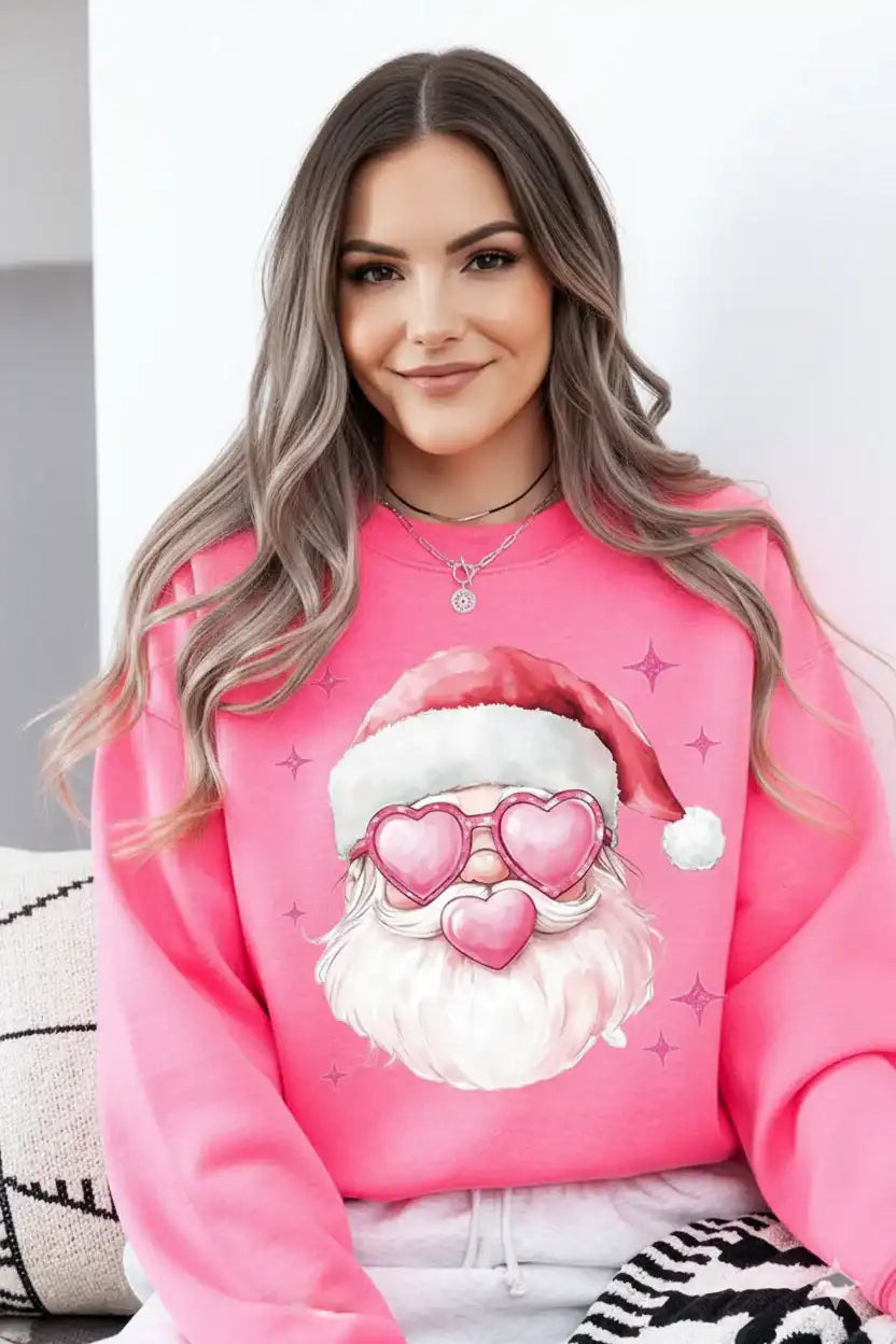 Person wearing a pink sweatshirt with a cartoon Santa Claus design.
