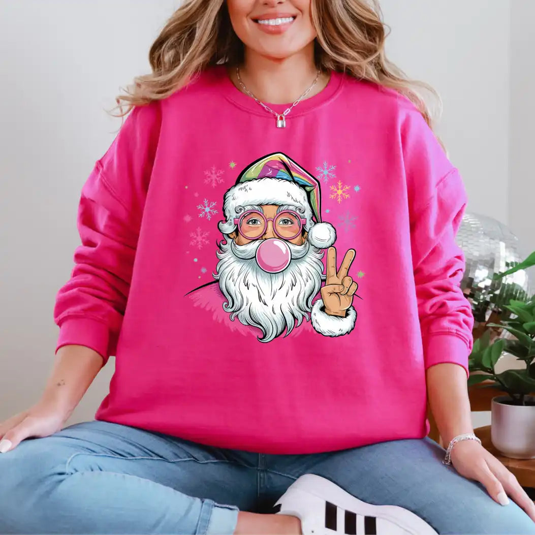 Person wearing a pink sweatshirt with a cartoon Santa Claus design, sitting indoors.