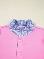 Pink women's blouse with blue and white striped ruffle collar and white buttons