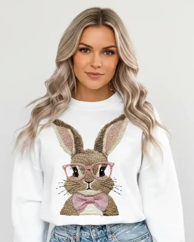 Woman wearing white sweatshirt with cute bunny graphic, pink glasses, pink bow, casual fashion