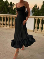 Black ruffle maxi dress with spaghetti straps, perfect for elegant evening wear or beachside style.
