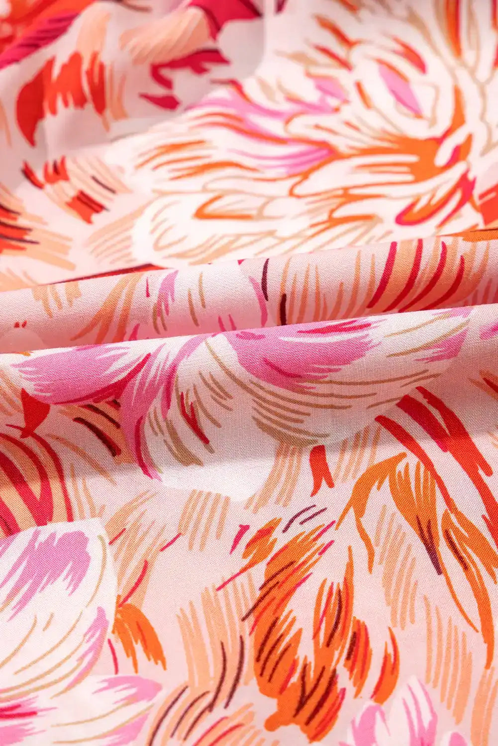 Pink and orange floral patterned fabric with soft, abstract brushstroke design