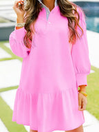 Woman wearing a loose pink long sleeve dress with ruffle hem, outdoor setting