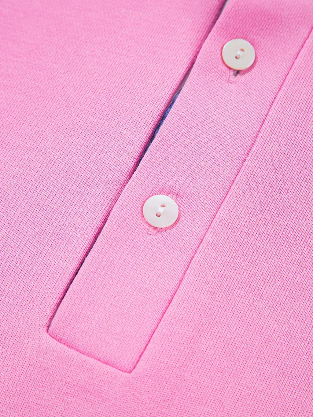 Close-up of pink knit women's polo shirt with white buttons