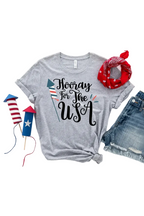 Gray t-shirt with 'Hooray for the USA' text, red bandana, denim shorts, and toy rockets on a white background