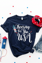 Navy blue t-shirt with 'Hooray For The USA' text, surrounded by red, white, and blue accessories on a white background.